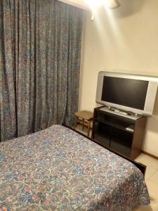 een hotelkamer met een bed en een flatscreen-tv bij Playa Club Argentina in Miramar