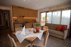 a kitchen and living room with a table and a couch at Villa Aylin in Prato alla Drava