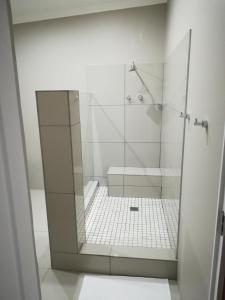 a shower with a glass door in a bathroom at Tranquil House B&B @ 121 Berry St in Queenstown