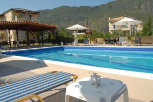 a large swimming pool with a table next to a house at Hotel Afrika in Eleonas