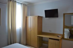 a bedroom with a bed and a television and a mirror at Villa Dei Fiori in Montoro Inferiore