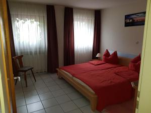 a bedroom with a red bed and a window at Hotel Restaurant Zur Hexe in Überherrn