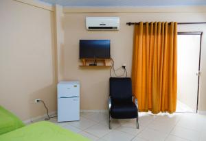 a room with a tv and a chair in a room at Class Apart Hotel in Encarnación