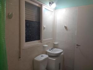 a bathroom with a toilet and a sink and a window at Terra in San Juan