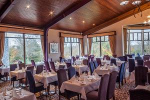 una sala de banquetes con mesas, sillas y ventanas en Westport Woods Hotel & Spa, en Westport