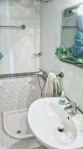 een witte badkamer met een wastafel en een bad bij 2 Room City-Sea apartment in Durrës