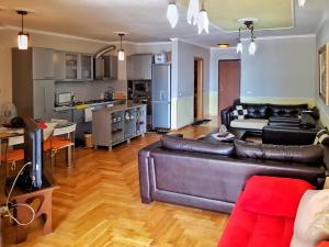 een woonkamer met een leren bank en een keuken bij 2 Room City-Sea apartment in Durrës
