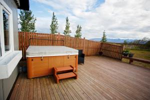 a porch with a bed and a bench on a deck at Hestaland Guesthouse Horse Farm Stay in Staðarhús +64 photos