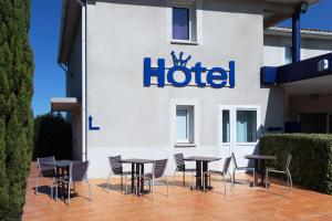 a hotel with tables and chairs in front of it at Audotel in Carcassonne