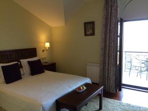 1 dormitorio con 1 cama y balcón con mesa en Quinta de Villanueva, en Colombres