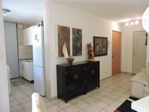 a living room with a couch and a kitchen at Central Montgaillard in Saint-Denis