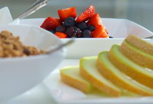 een bord met fruit en een kom ontbijtgranen bij Onefifty in Cowes