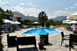 una piscina en un complejo con sillas y sombrillas en Annamaria Studios & Apartments, en Petra