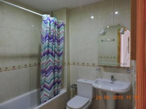 ein Badezimmer mit Toilette, Waschbecken und Spiegel in der Unterkunft 29 Calle Cártama in La Cala de Mijas