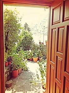 Guesthouse Gouris في تسيبيلوفو: باب يؤدي إلى حديقة بها نباتات الفخار