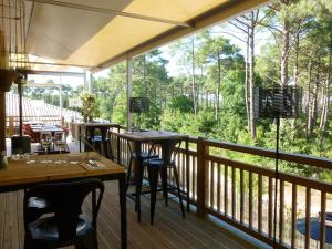 a restaurant with tables and chairs on a balcony at Domaine du Ferret Restaurant & Spa in Cap-Ferret