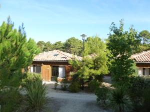 a house with a lot of trees in front of it at Domaine du Ferret Restaurant & Spa in Cap-Ferret