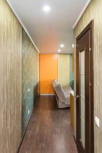 a hallway with a couch and an orange wall at Apartment na Respubliki in Tyumen