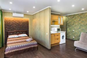 チュメニにあるApartment na Respublikiの小さなベッドルーム(ベッド1台付)、キッチンが備わります。