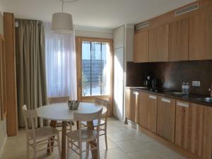 a kitchen with a white table and chairs and a window at Domaine du Ferret Restaurant & Spa in Cap-Ferret