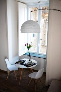 tavolo e sedie in una stanza con finestra di casa vacanza il sole di Napoli a Napoli