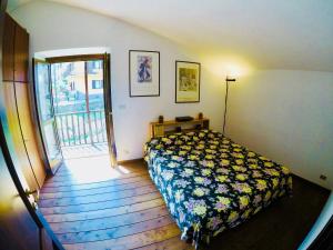 a bedroom with a bed and a door to a balcony at ViviMontagna Katherina in Perosa Argentina