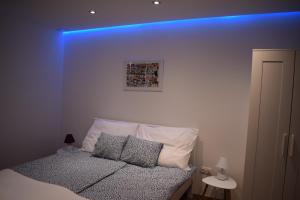 1 dormitorio con 1 cama con luz azul en Buborék apartman, en Tata