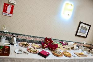 stół z wieloma talerzami jedzenia w obiekcie Hotel Kroma w mieście Ragusa