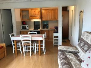 a kitchen and living room with a table and chairs at Studio pied de pistes balcon et vue montagne in Montgenèvre +2 photos