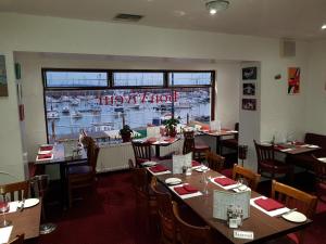 un ristorante con tavoli e sedie e una finestra di Bon Viveur Guest House a Saint Aubin