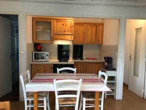 a kitchen with a table and chairs in a room at Studio pied de pistes balcon et vue montagne in Montgenèvre