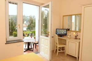 Habitación con escritorio, ordenador y ventana. en Il Cottage B&B, en Massa Lubrense