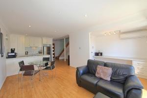 sala de estar con sofá y mesa de cristal en Alexandra Apartments, en Bundaberg