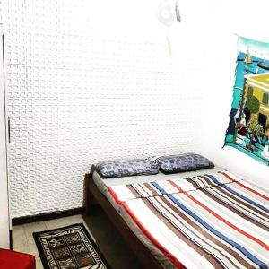 a bed in a room with a white brick wall at Hostel Itapua in Salvador