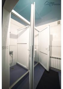 a bathroom with white doors and a blue floor at Pik Evropi in Tegenekli