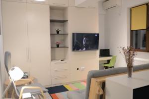 een woonkamer met een tv aan de muur bij Cozy Apartments - City Center in Iaşi