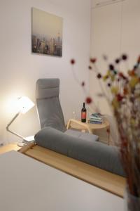 een woonkamer met een stoel en een tafel bij Cozy Apartments - City Center in Iaşi
