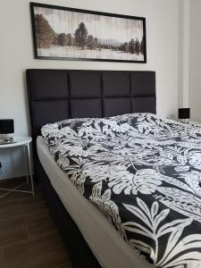 a bed in a bedroom with a black and white blanket at Fantastic Four Apartments in Neoi Epivates