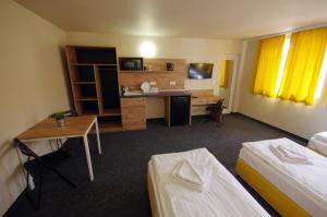 Pokój hotelowy z 2 łóżkami i biurkiem w obiekcie Стаи за Гости "ЦЕНТРАЛ" Фамилни Стаи & Апартаменти w mieście Gabrowo