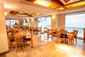 a restaurant with tables and chairs in a room at Hotel Plaza Calzada in Monterrey