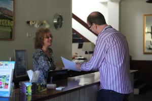 a man and a woman standing at a cash register at Titania Motel in Oberon
