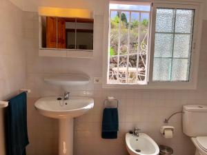 a bathroom with a sink and a toilet and a window at Casita Vista Valle 35 in El Paso +9 photos
