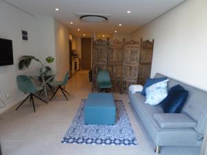 a living room with a blue couch and a table at Ocean Dune Studio in Sibaya
