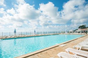 Ein Swimmingpool mit Liegestühlen und dem Meer im Hintergrund in der Unterkunft Effect Algara Beach Resort - Ultra All Inclusive and Free Parking in Kranewo