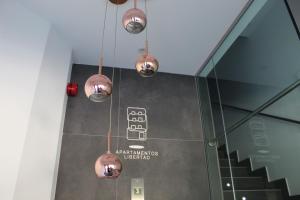 un grupo de luces colgando del techo en una habitación en Salamanca Suites Libertad, en Salamanca