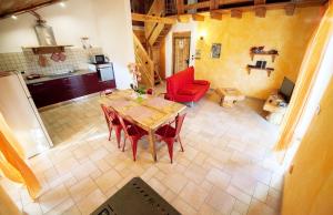 una cucina e una sala da pranzo con tavolo e sedie rosse di maison povil a Quart