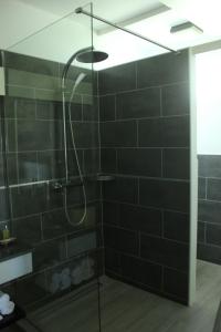 La salle de bains est pourvue d'une douche avec du carrelage noir. dans l'établissement Studio Montgérald, à Fort-de-France