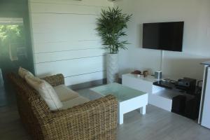 a living room with a wicker chair and a white table at Studio Montgérald in Fort-de-France