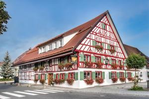 ein rot-weißes Gebäude mit Blumen an den Fenstern in der Unterkunft BIO-Hotel Adler/Restaurant in Vogt