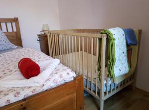 a crib with a red hat on it in a bedroom at Chalupa u kostela in Lukov